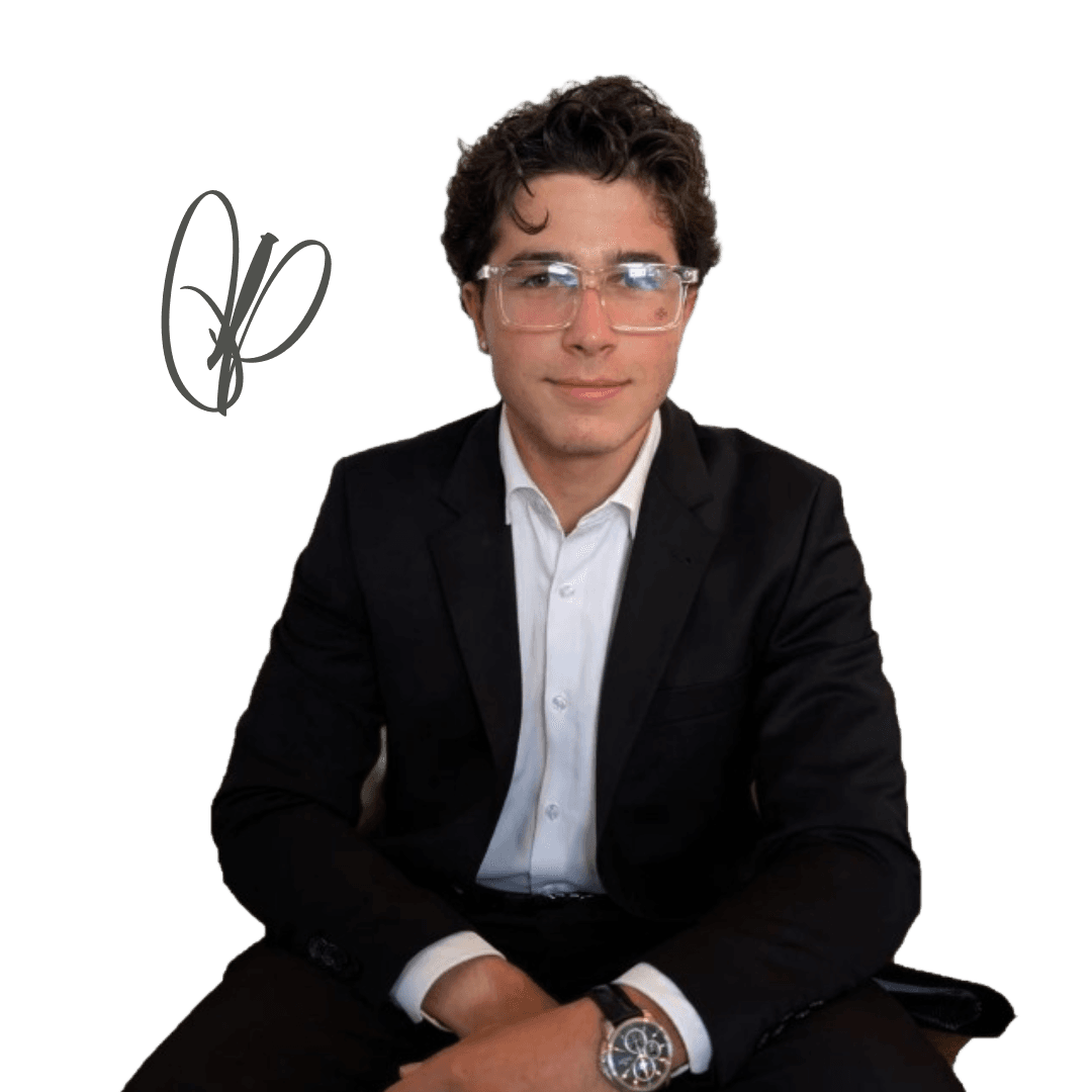 Young man with curly hair and clear glasses wearing black suit jacket and white shirt.